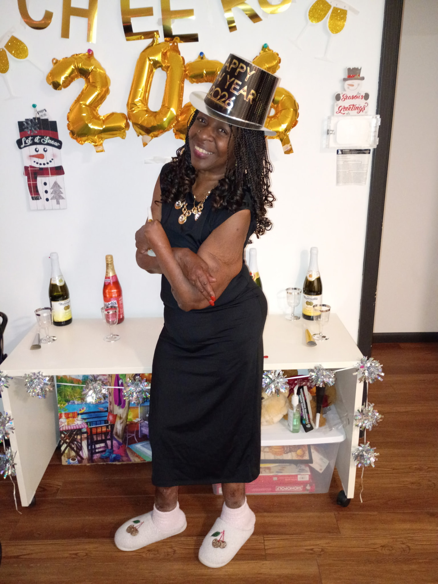 A resident posing in a New Year's hat under Cheers 2026 decorations